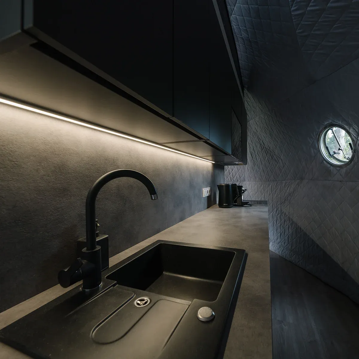 Kitchenette inside the dome — sink, worktop and a stocked fridge