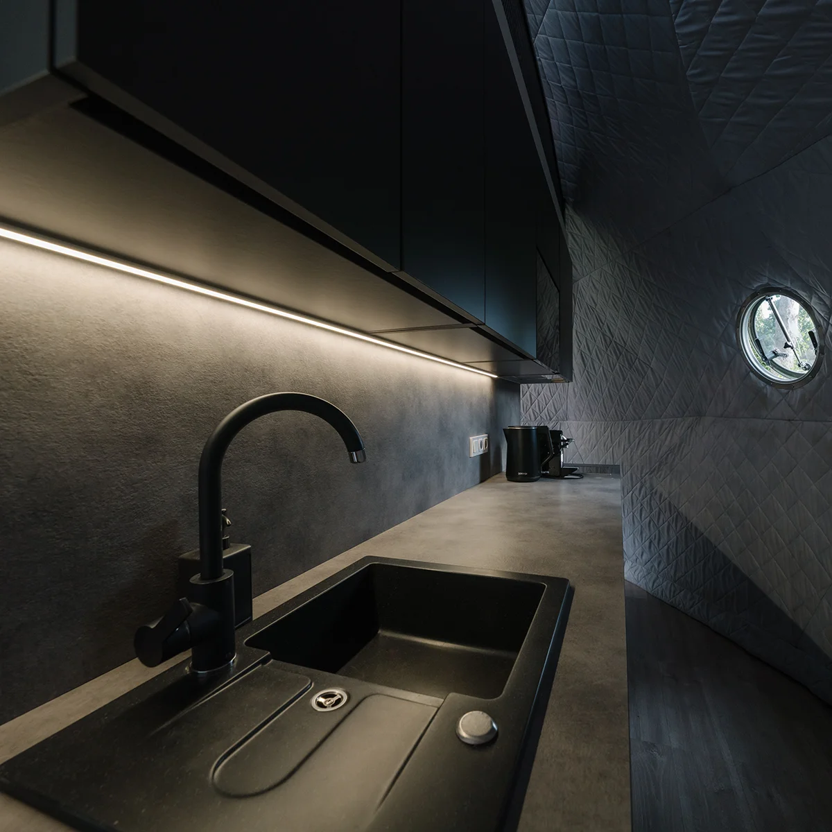Kitchenette inside the dome — sink, worktop and a stocked fridge