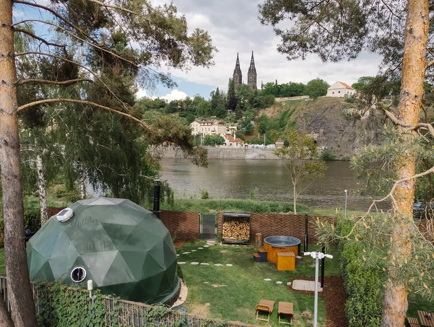 Geodesic dome and garden by the Vltava with the historic Vyšehrad across the river